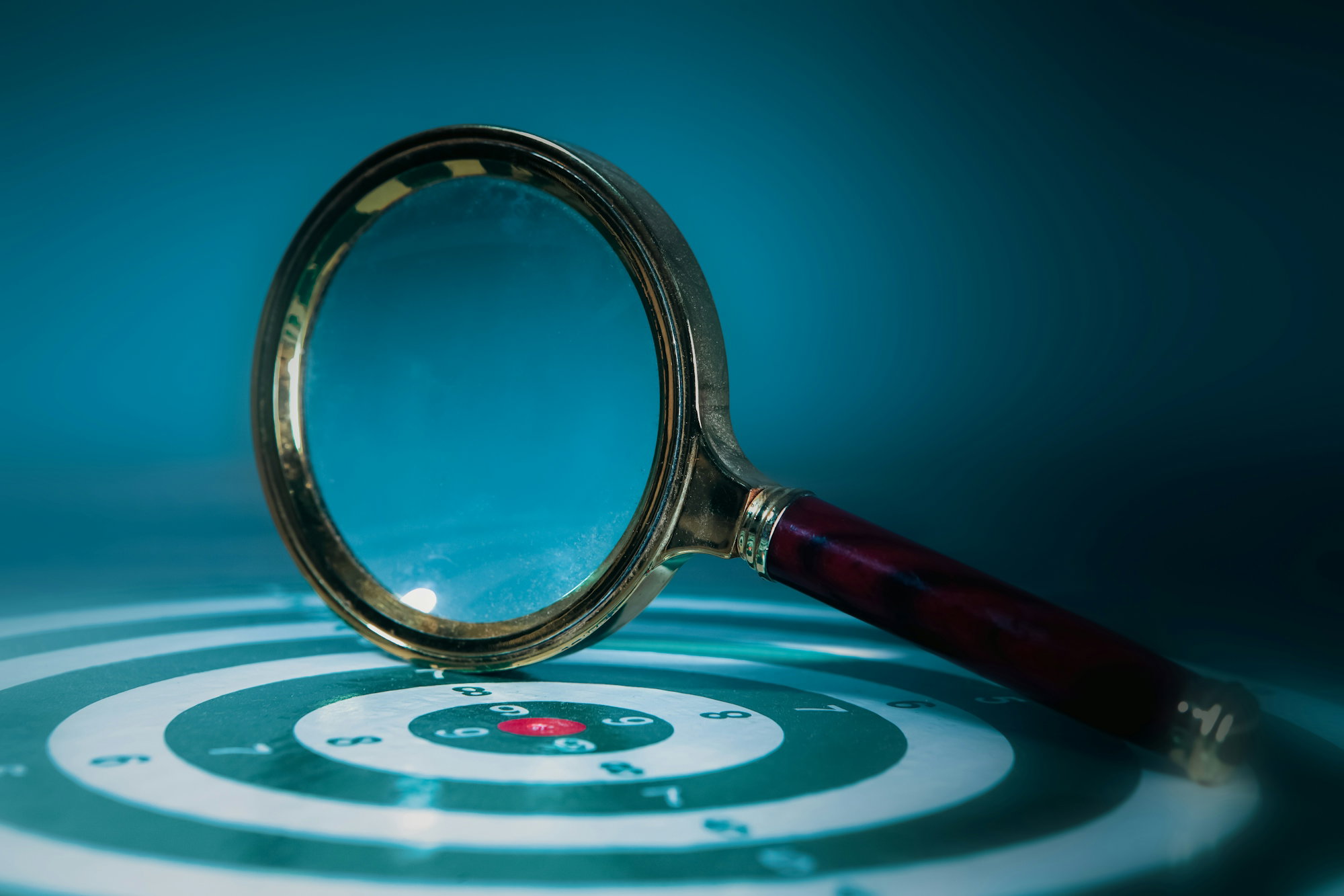 magnifying-glass-over-a-target-with-bullseye-.jpg Magnifying glass over a target with bullseye.